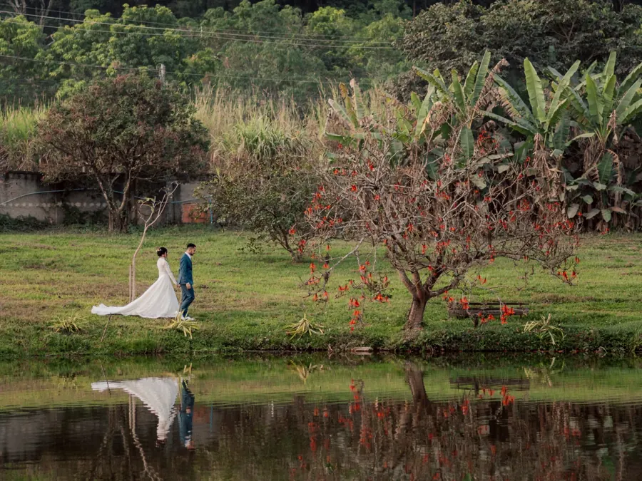 Casal caminhando à beira da lagoa